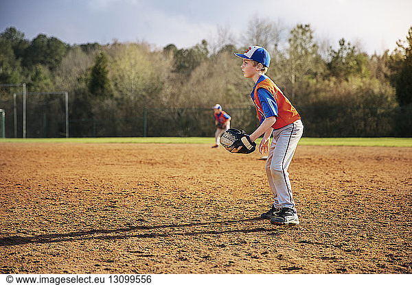 Side view of boy playing baseball on field