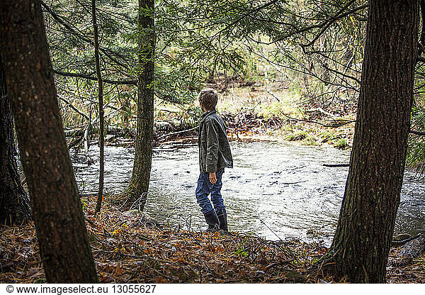Side view of boy standing by river