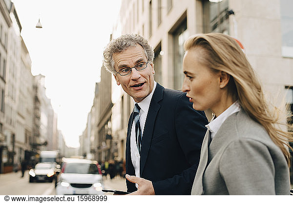 Side view of businessman talking to female colleague in city