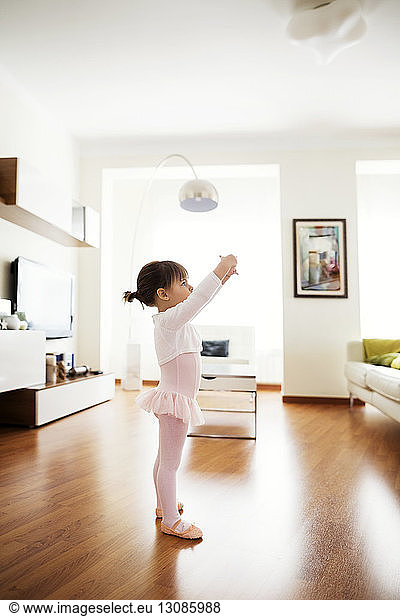 Side view of girl performing ballet dance at home