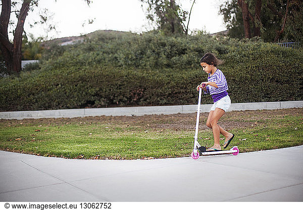 Side view of girl riding push scooter at park