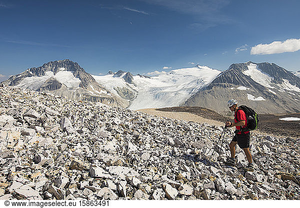 Side view of hiker crossing rugged terrain.