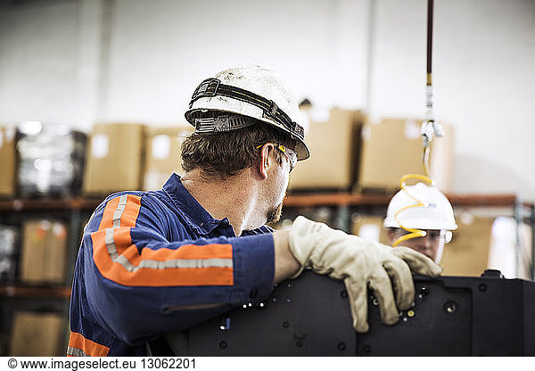 Side view of male workers checking electrical equipment in recycling plant