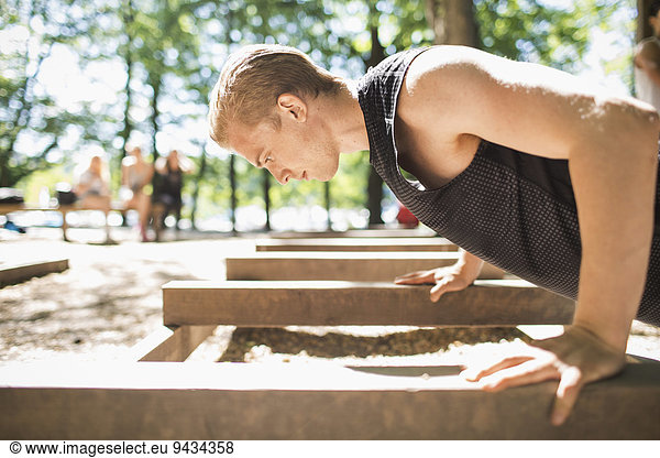 Side view of man doing push-ups at outdoor gym
