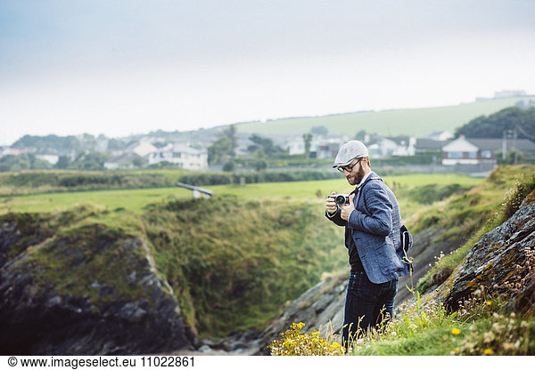 Side view of man photographing on hill