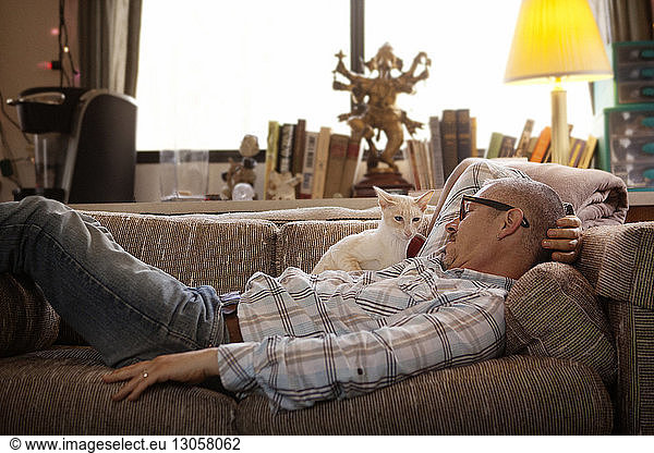 Side view of man relaxing on sofa at home