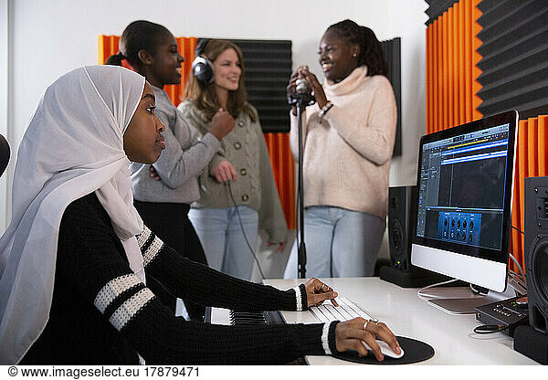 Side view of teenage musician working in recording studio