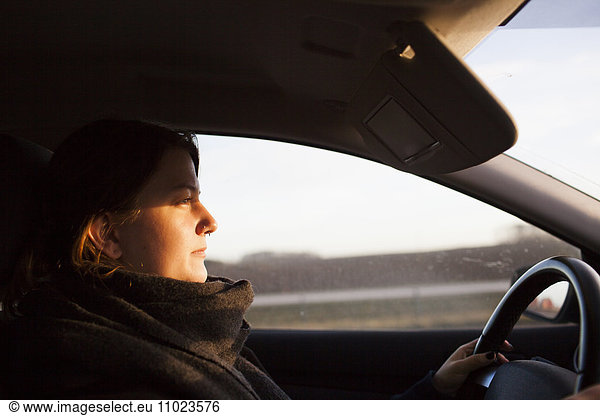 Side view of woman driving car
