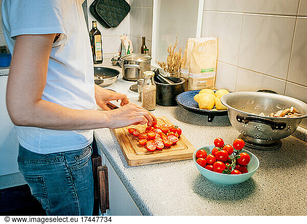 Side view of woman in kitchen while preparing dinner of vegetables