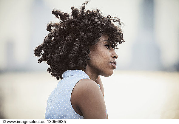 Side view of woman with curly hair looking away