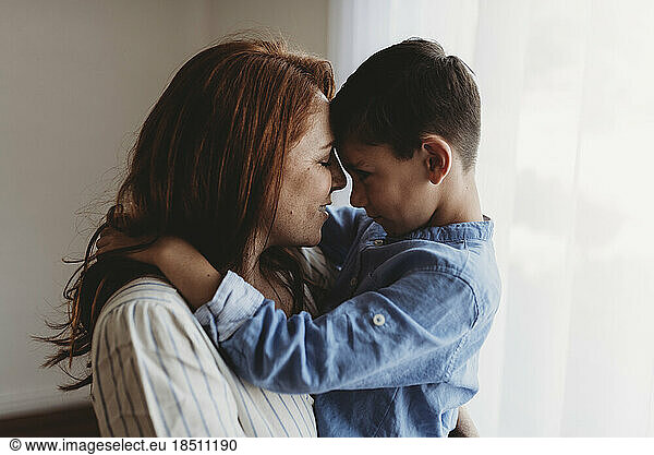 Side view of young mother embracing young boy in studio