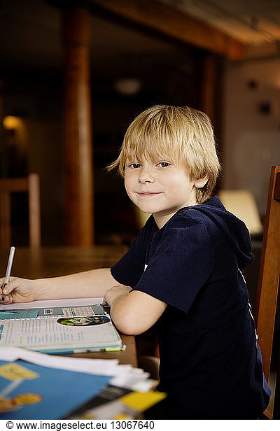 Side view portrait of cute boy studying at table