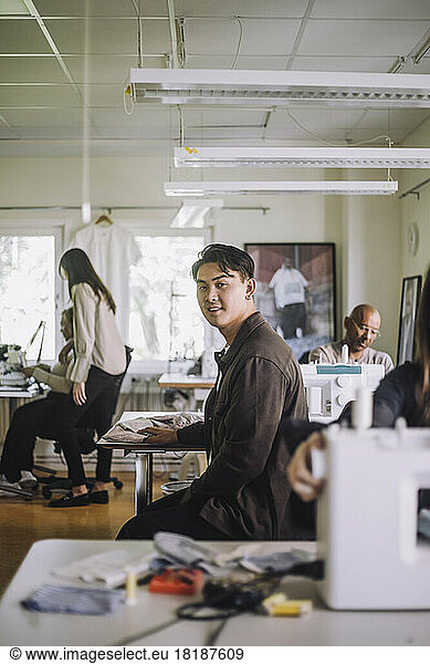 Side view portrait of male design professional sitting at workshop