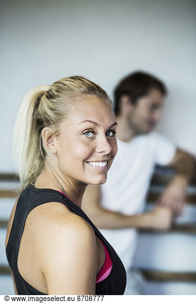 Side view portrait of smiling woman at gym