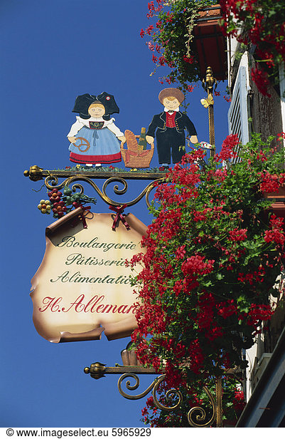 Sign outside traditional patisserie  red flowers prominent  Eguisheim  Haut-Rhin  Alsace  France  Europe