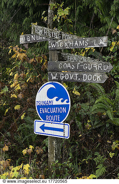 Signpost with landmark and Tsunami Evacuation route signs in Bamfield on Vancouver Island; Bamfield  British Columbia  Canada