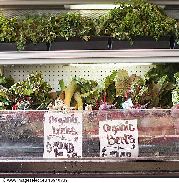 Signs in an organic produce display fridge.