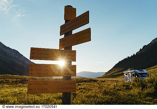Signs indicating mountain routes with motor home during sunset at Col des Aravis;Haute-Savoie
