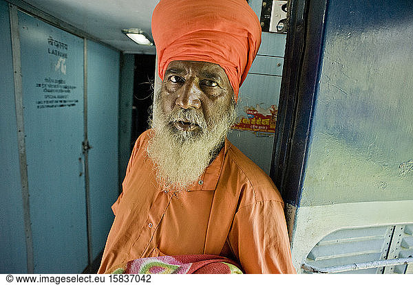 Sikh in elegant orange clothes in a train