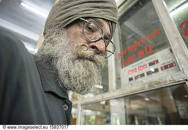 Sikh man with big mustache in the train station ticket office