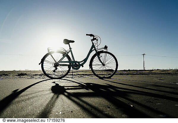 Silhouette bicycle parked at Fangar Beach against clear sky in sunlight  Ebro delta. Spain