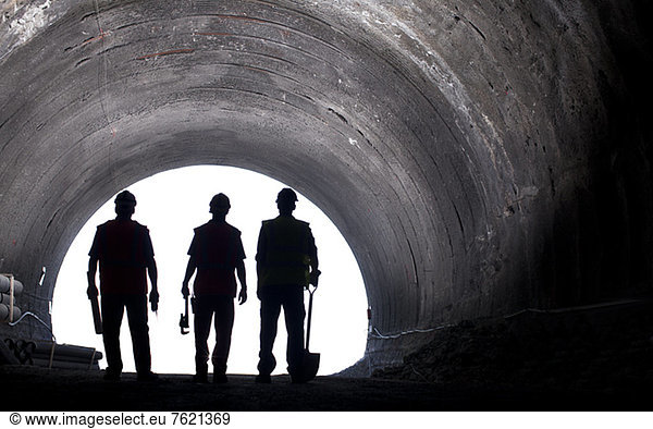 Silhouette der Arbeiter im Tunnel