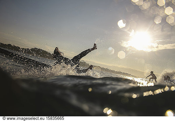 Silhouette der Surfer bei Sonnenuntergang