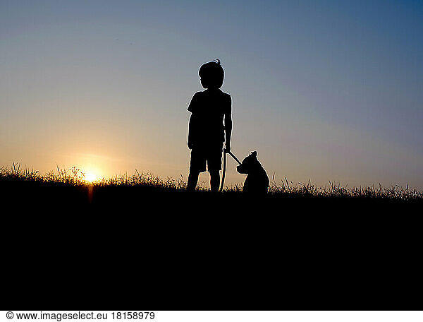 Silhouette eines Jungen und eines Hundes