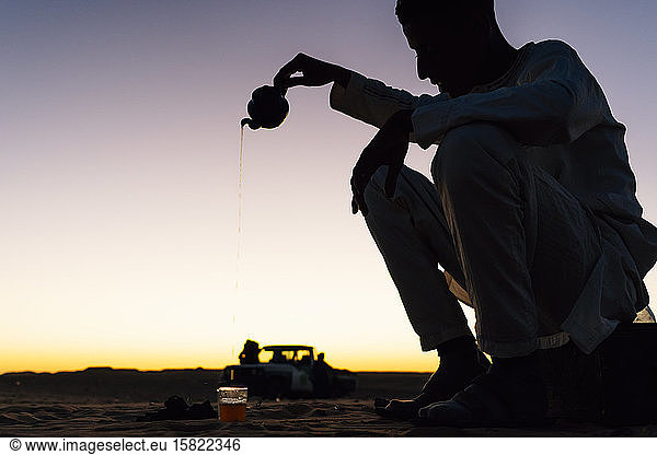 Silhouette eines Mannes  der in der Wüste Sahara Tee zubereitet  Tindouf  Algerien