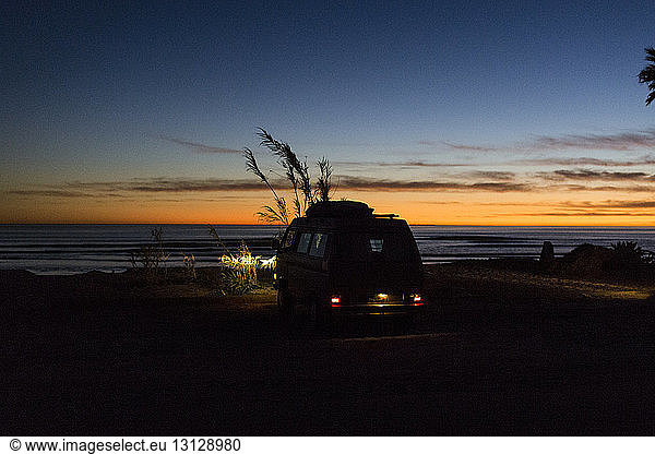 Silhouette mini van on San Onofre State Beach during sunset