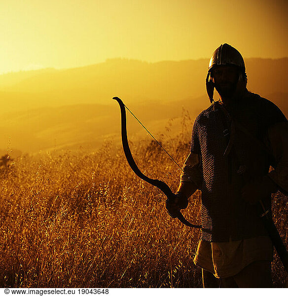 Silhouette of a man dressed as a warrior holding a bow. California  United States