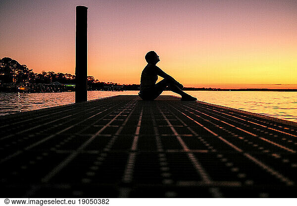 Silhouette Of A Person On A Dock