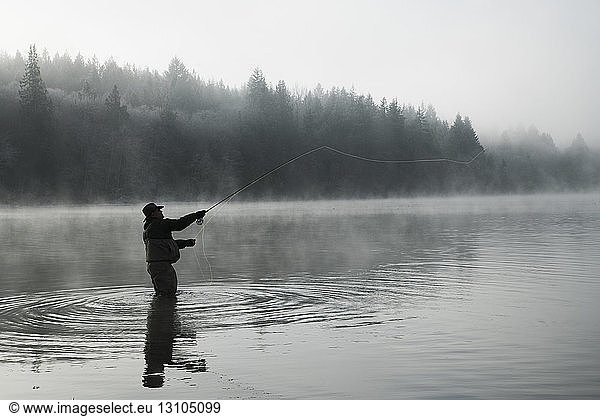 Silhouette of fisherman fly fishing for salmon and sea run cutthroat trout