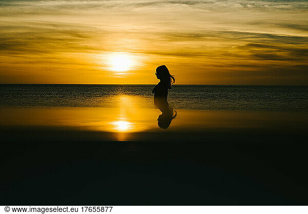 Silhouette of girl in golden sunset over east chine sea