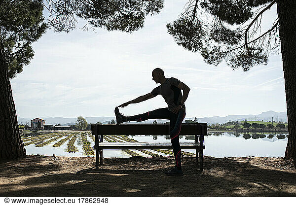 Silhouette of man doing stretching exercise