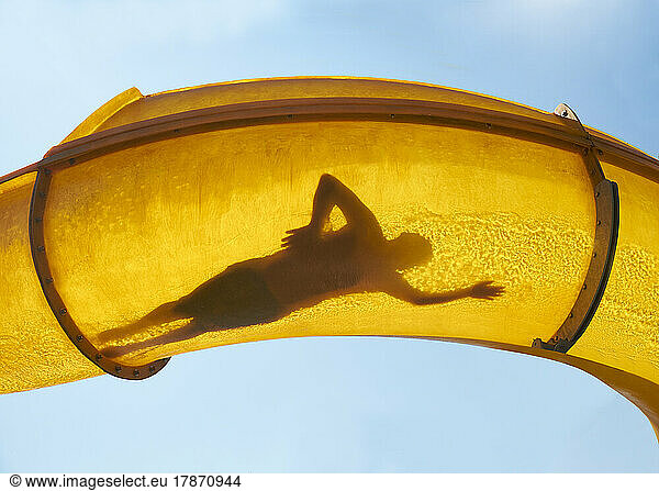 Silhouette of person sliding down water slide