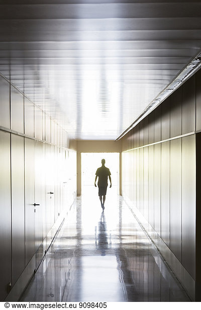 Silhouette of person walking in corridor