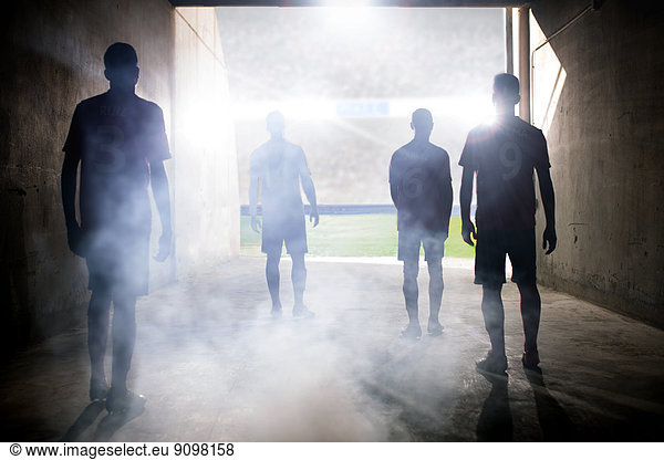 Silhouette of soccer teams facing field