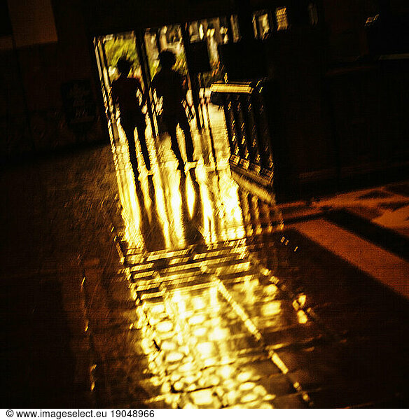 Silhouette of two people walking.