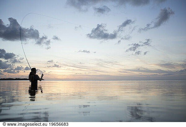 Silhouette of woman fishing
