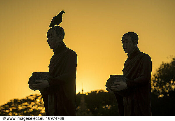 Silhouettes of monk statues at Myo Yar Pyae Pagoda at sunset  Mo