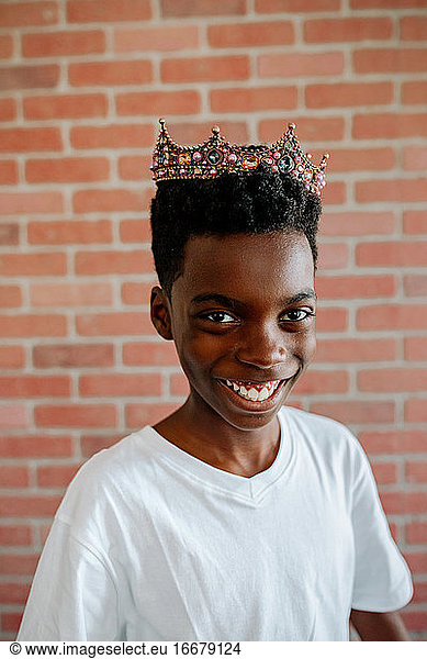 Silly preteen African-American boy wearing jeweled tiara