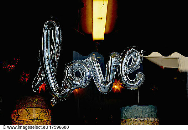 Silver colored balloon in shape of word love