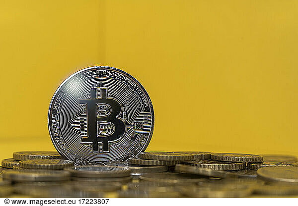 Silver colored bitcoin among coins