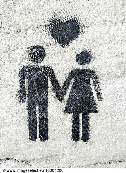 Simple graffiti depicting heart above heterosexual couple holding hands