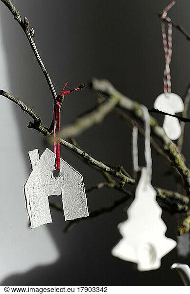 Simple house-shaped decoration hanging on twig