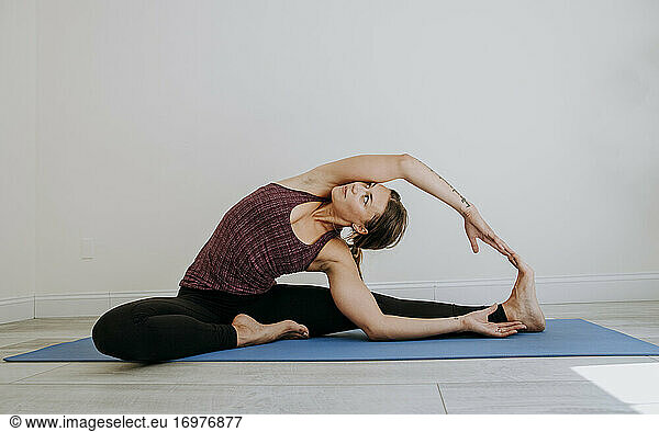Simple white room provides backdrop for woman practicing yoga