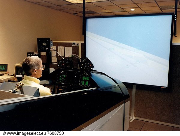 Simulation Group Leader Martha Evans is seen here at the controls of the F_18 aircraft simulator at NASA´s Dryden Flight Research Center  Edwards  California. Simulators offer a safe and economical alternative to actual flights to gather data  as well as being excellent facilities for pilot practice and training. The highly modified F_18 airplane flew 383 flights over a nine year period and demonstrated concepts that greatly increase fighter maneuverability. Among concepts proven in the aircraft is the use of paddles to direct jet engine exhaust in cases of extreme altitudes where conventional control surfaces lose effectiveness. Another concept  developed by NASA Langley Research Center  is a deployable wing_like surface installed on the nose of the aircraft for increased right and left yaw control on nose_high flight angles.