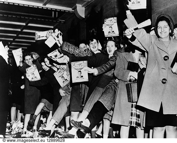 SINATRA FANS  1945. A crowd of teenage girls with copies of 'Song Hits' magazine  waiting for Frank Sinatra at the Paramount Theatre in New York City. Photograph  1945.
