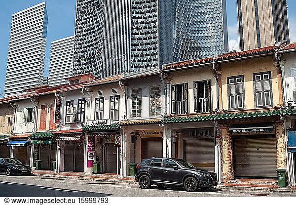 Singapore  Republic of Singapore  Asia - Old buildings built in the style of traditional shophouses are towered by modern high-rise buildings in the Muslim Quarter (Kampong Glam). Apart from a few relevant stores like grocery shops and pharmacies  most retailers are closed during the partial lockdown amid the corona crisis (Covid-19).